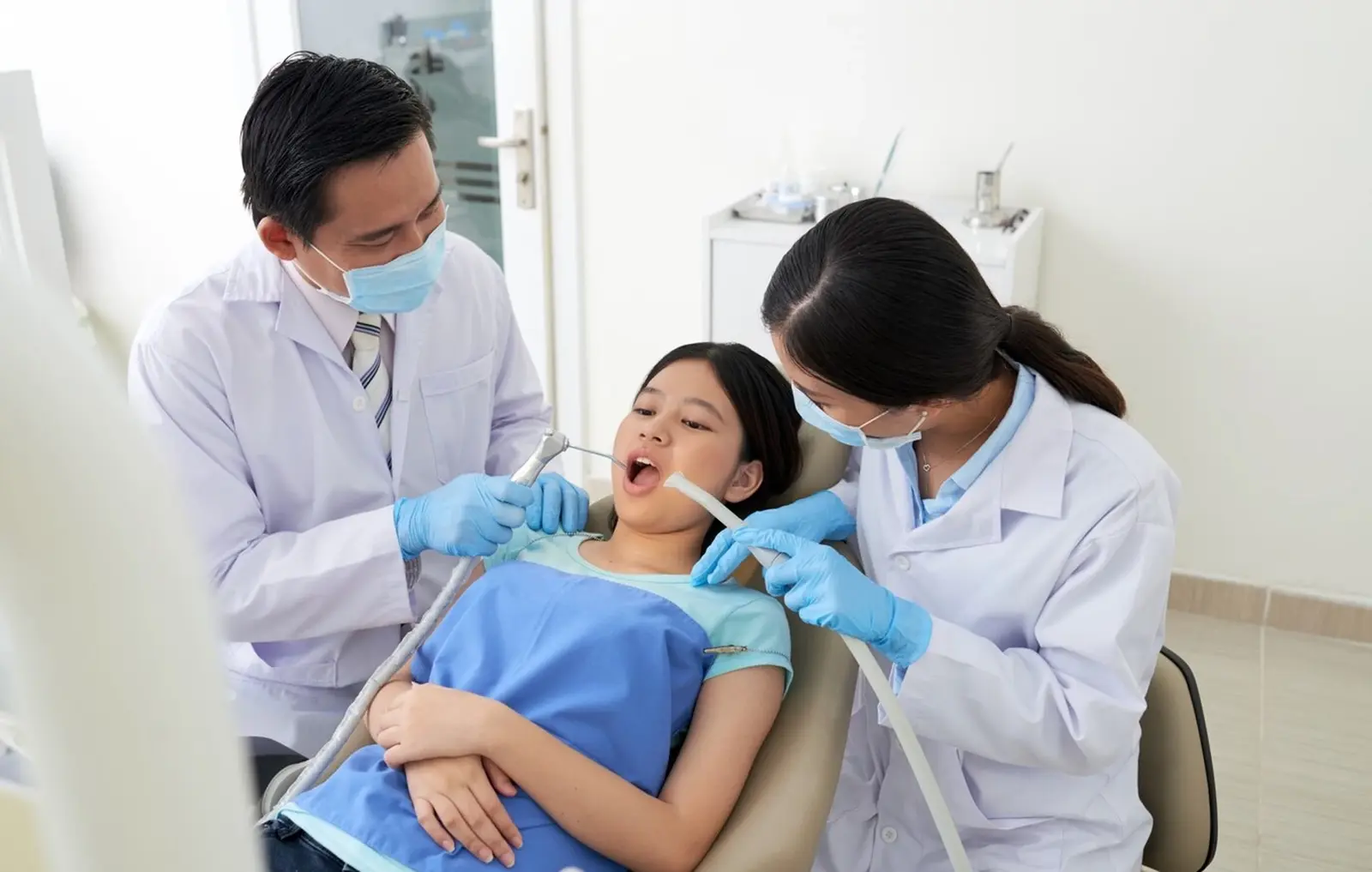Dentista atendiendo a una paciente sonriente en el sillón de la clínica